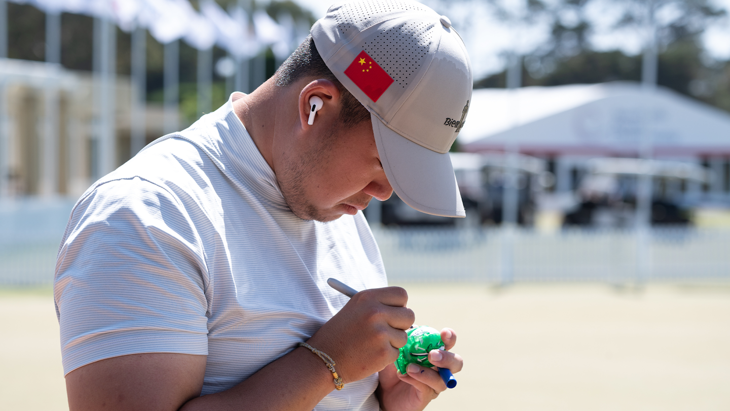 Yunhe Zheng of China marks his ball prior to the final round